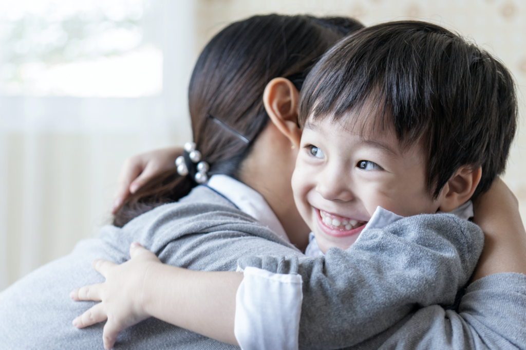 asian cute boy smiling with happily hugging with mother