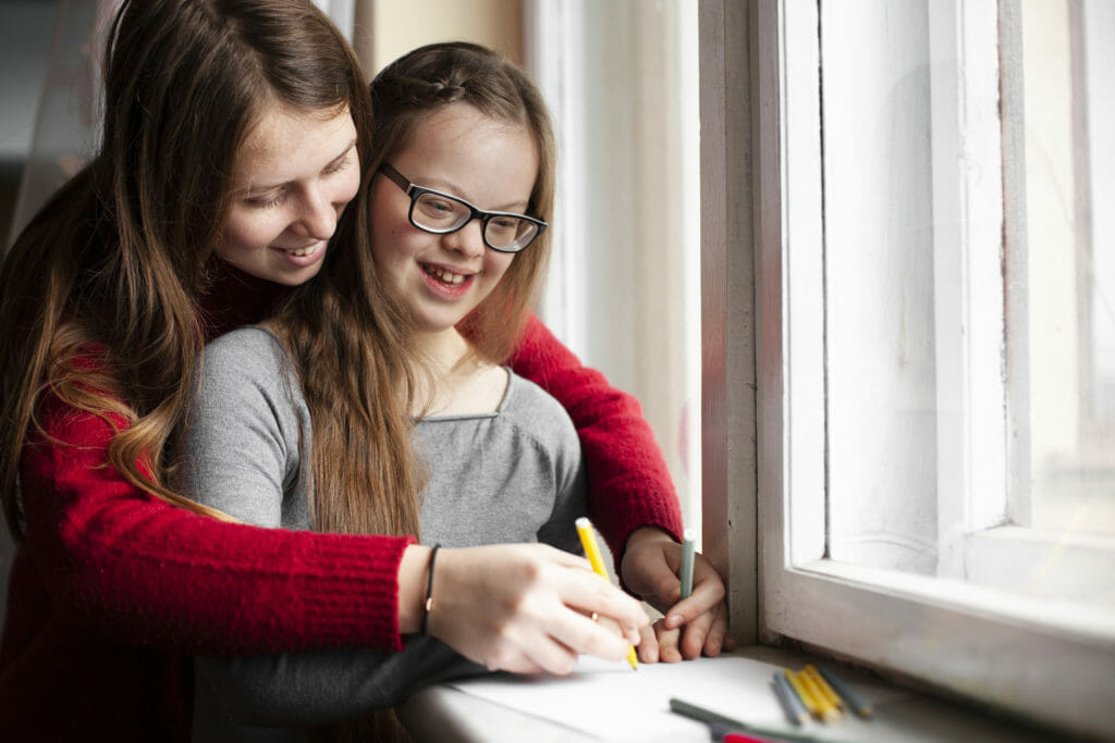 woman with happy girl with down syndrome drawing 3556422