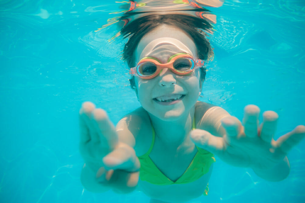 kid having fun swimming pool underwater portrait child summer vacation