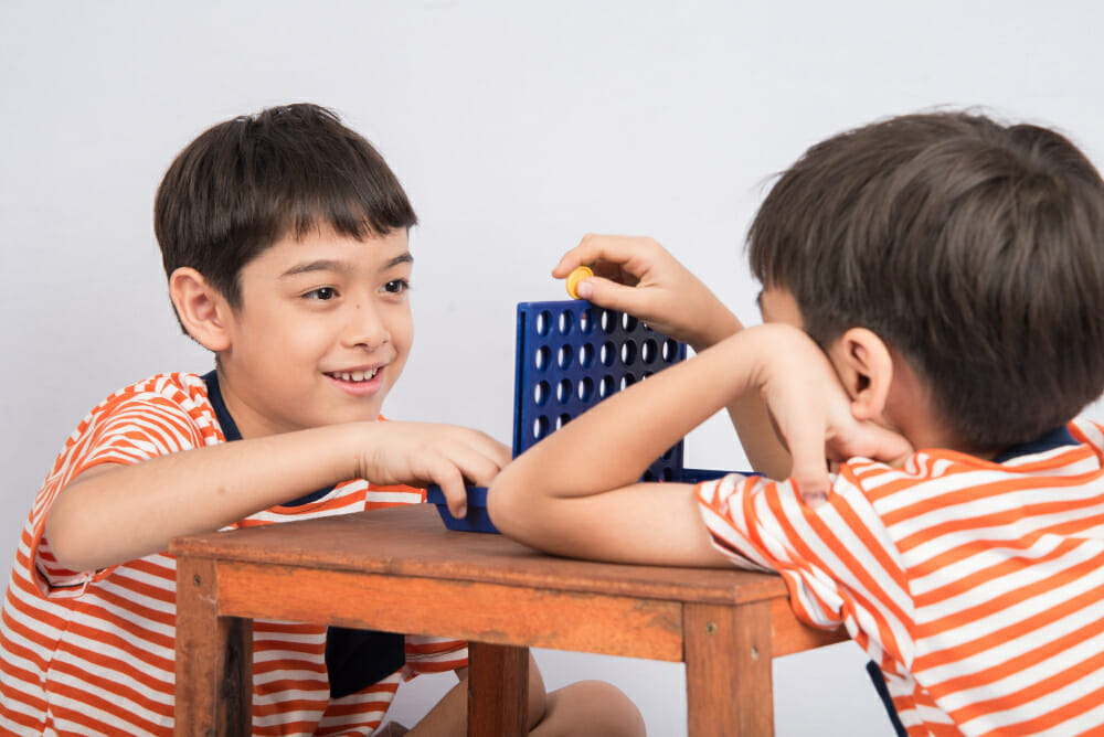 little boy playin connect four game soft focus eye contact